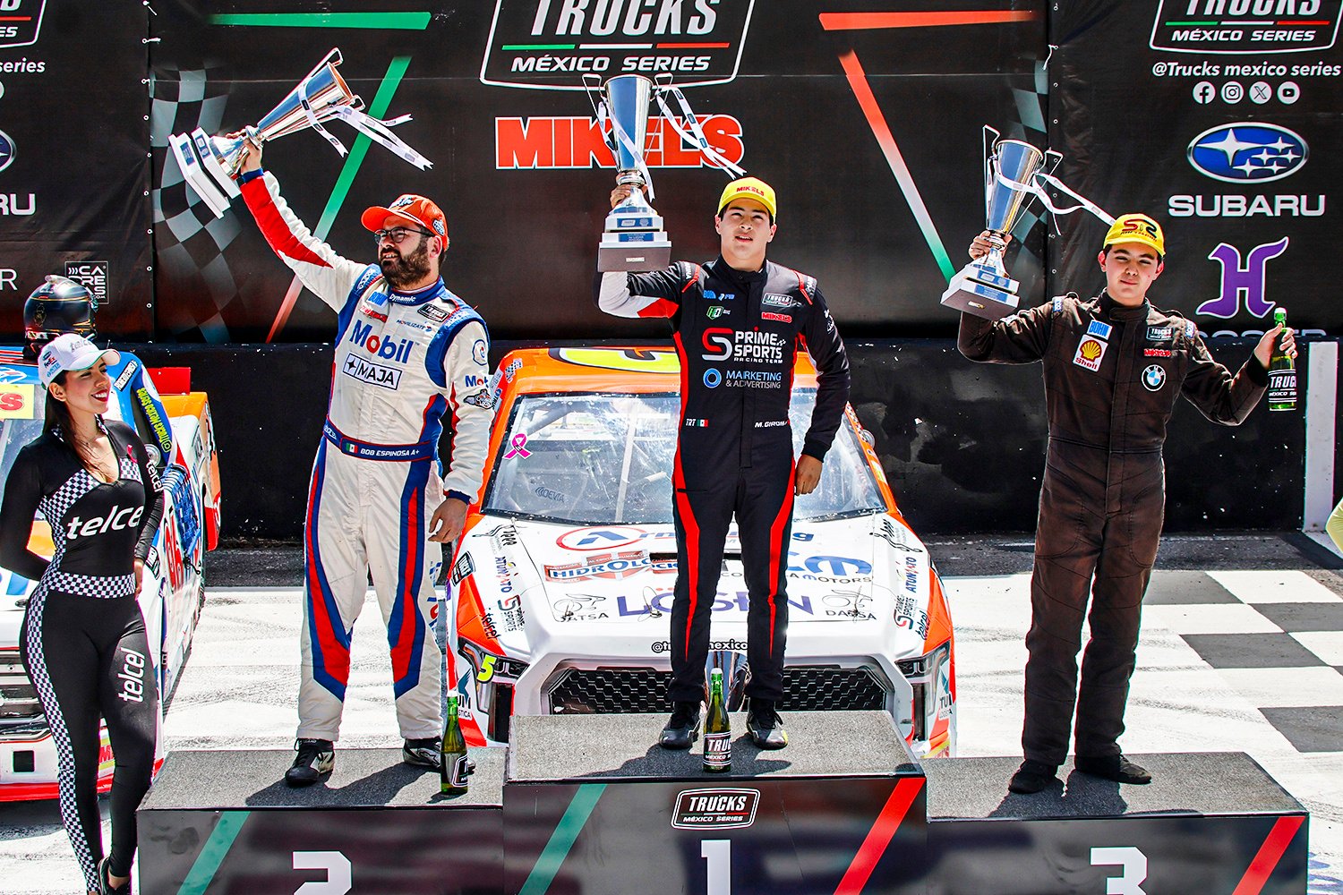 Mateo Girón levanta el trofeo en lo más alto del podio de la Trucks México Series, con su camioneta #5 detrás.
