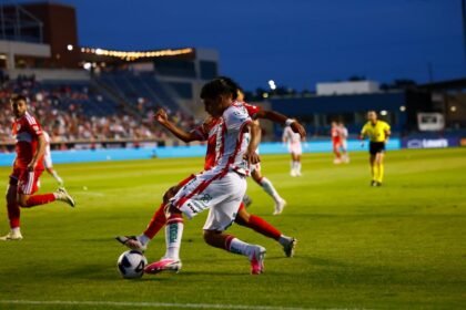 Jugador de Necaxa conduce el balon en el Estadio Victoria