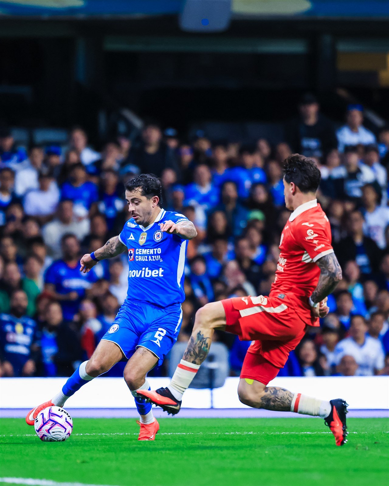 Alan Mozo, de Cruz Azul, conduce el balón ante la marca de un jugador de FC Juárez
