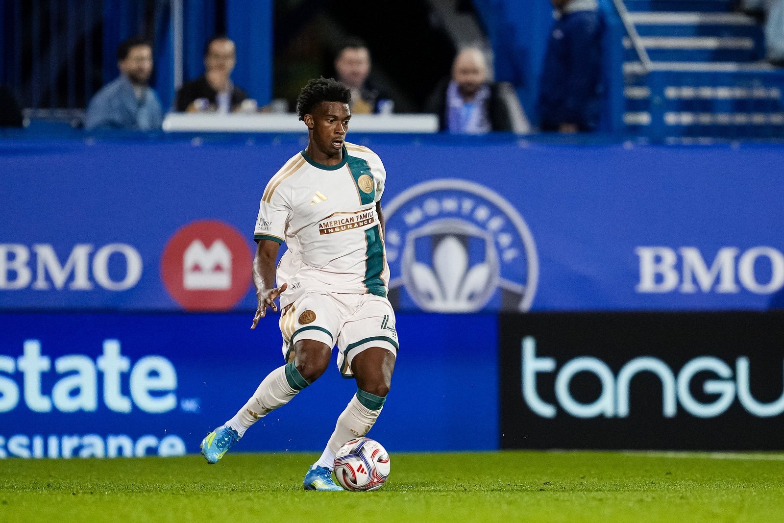 Un jugador de Atlanta United con el uniforme blanco conduce el balón frente a la publicidad del Stade Saputo durante el partido ante CF Montréal.