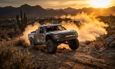 Ilustración: camioneta de carreras avanzando por el desierto de Baja California Sur al atardecer, entre cactus y una nube de polvo