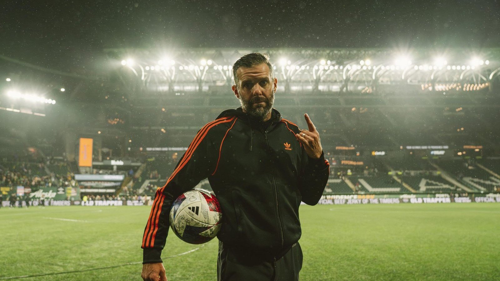 Ben Olsen, entrenador del Houston Dynamo, con un balón bajo el brazo en un estadio