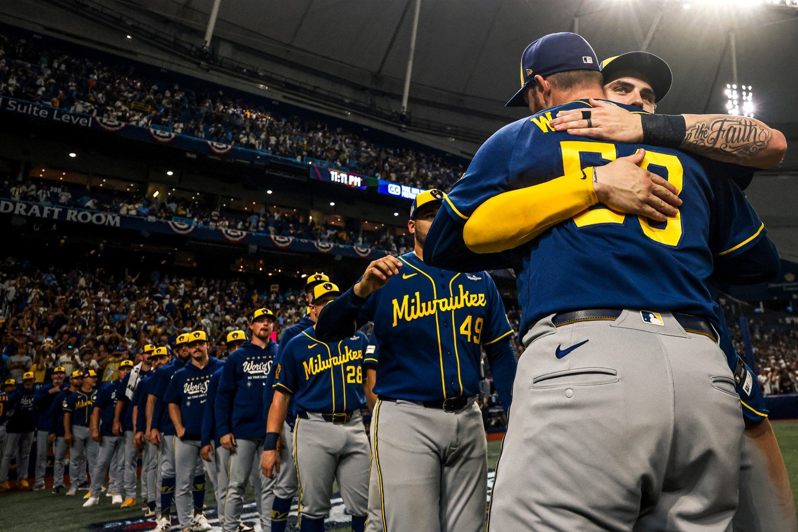 Jugadores de los Brewers se abrazan en el Tropicana Field durante la Serie Mundial 2026