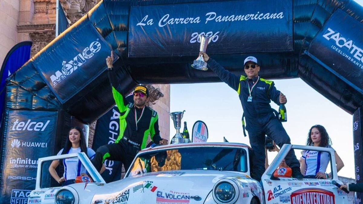 Una tripulación celebra con un trofeo en alto sobre un Studebaker, en el arco de meta de la Carrera Panamericana 2026 en Zacatecas