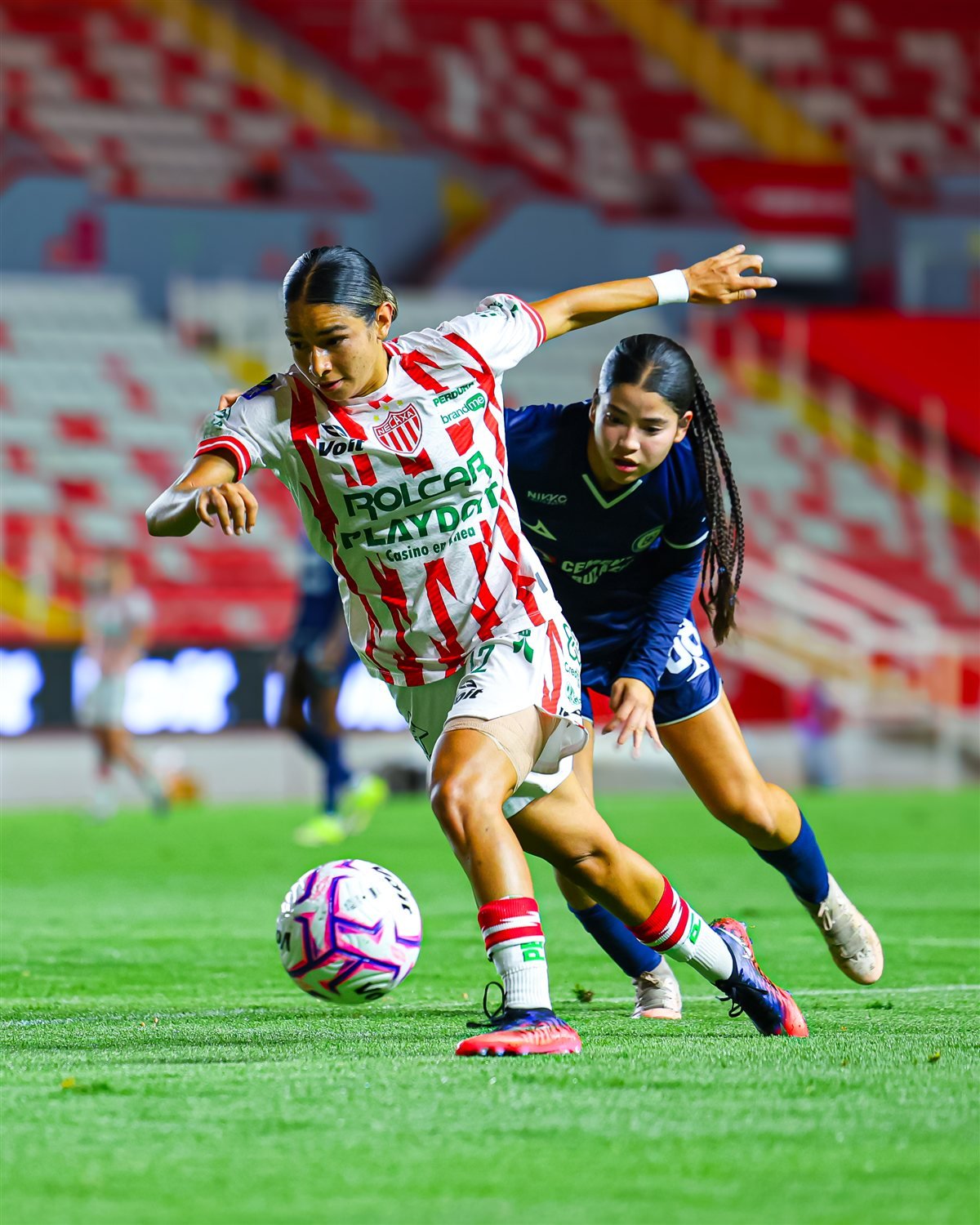 Una jugadora de Centellas del Necaxa disputa el balón con una rival de Cruz Azul durante el partido de la Jornada 10 de la Liga MX Femenil.