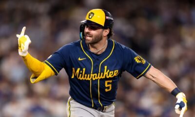 Garrett Mitchell, de los Cerveceros de Milwaukee con el número 5, señala con el dedo mientras corre las bases tras conectar un jonrón ante los Dodgers.