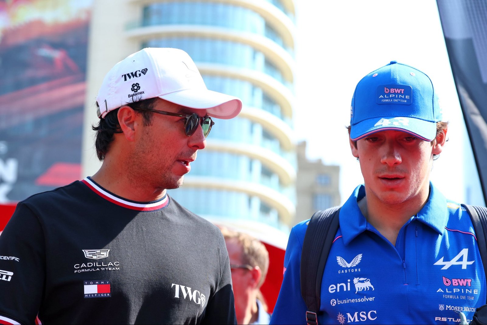 Checo Pérez, con gorra de Cadillac, conversa con un integrante de Alpine en el Gran Premio de México 2026