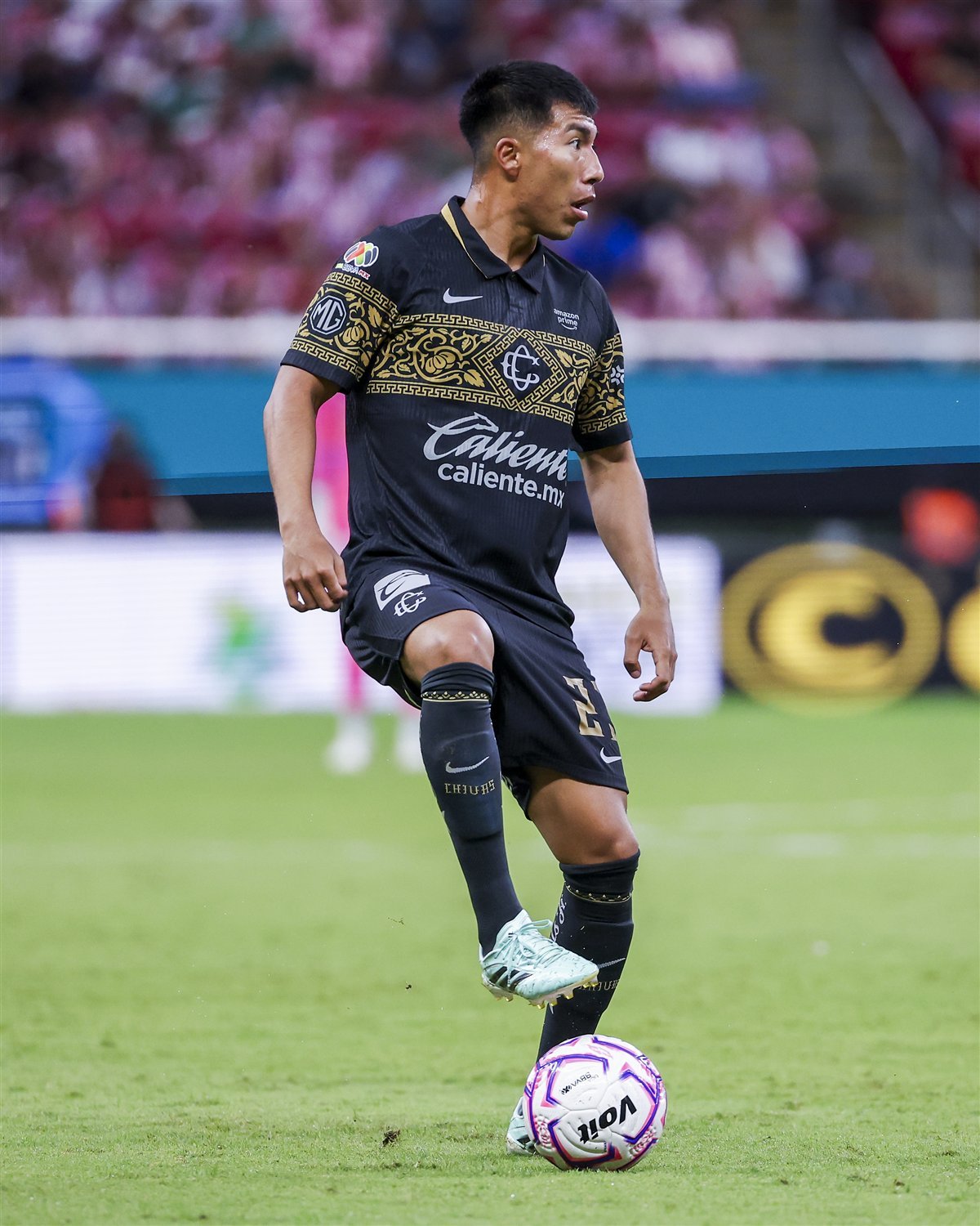 Jugador de Chivas conduce el balón en el Estadio Akron durante el partido ante Necaxa