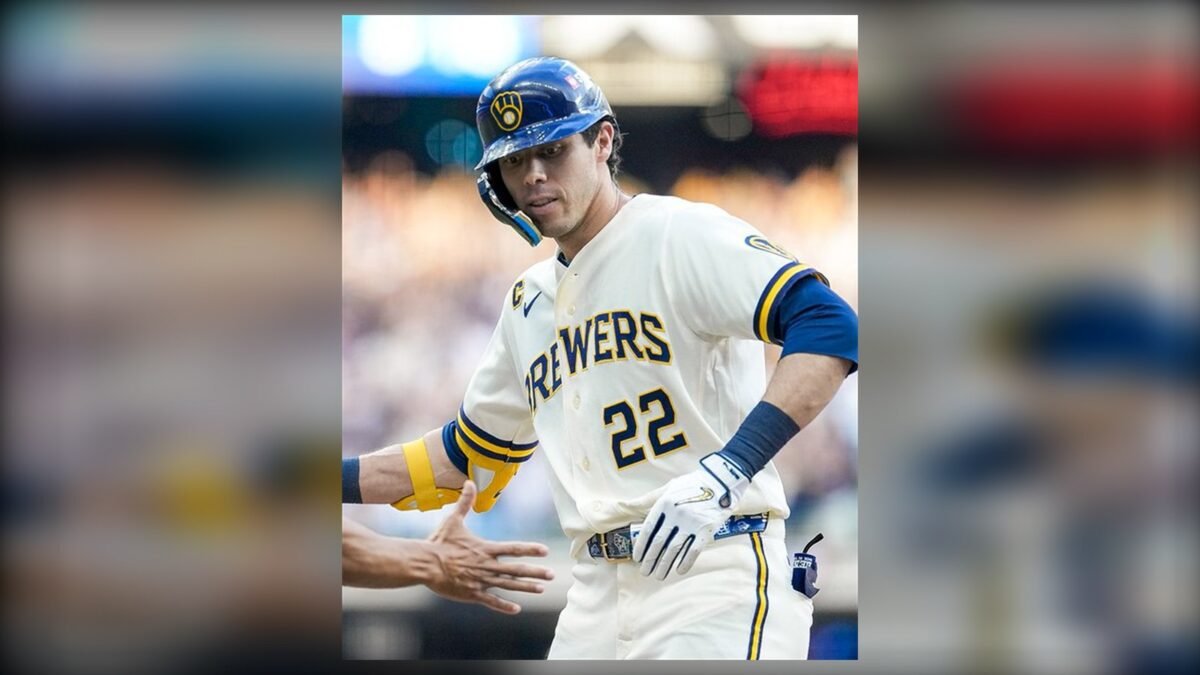 Christian Yelich, con el número 22 de los Cerveceros de Milwaukee, saluda a un compañero tras llegar a base.