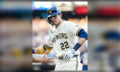 Christian Yelich, con el número 22 de los Cerveceros de Milwaukee, saluda a un compañero tras llegar a base.