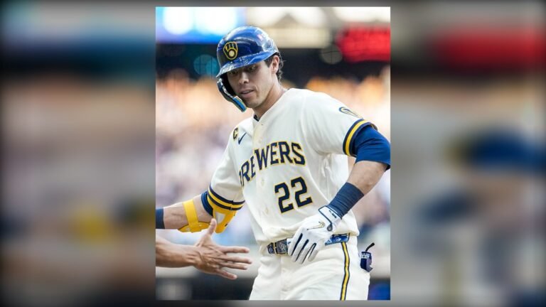 Christian Yelich, con el número 22 de los Cerveceros de Milwaukee, saluda a un compañero tras llegar a base.