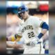 Christian Yelich, con el número 22 de los Cerveceros de Milwaukee, saluda a un compañero tras llegar a base.