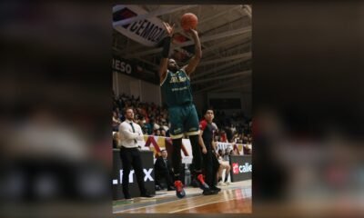 Mineros vs Diablos Rojos: un jugador de Diablos Rojos con la camiseta verde lanza un triple en el Gimnasio Marcelino González durante la serie del Play-In ante Mineros.