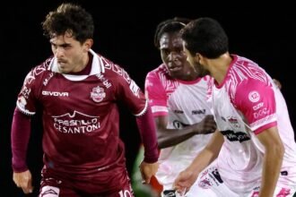 Jugador de Mineros de Zacatecas con el número 19 conduce el balón ante dos rivales de Alacranes de Durango.