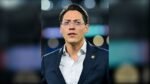 Enrique Nieto Junco, directivo de la Federación Mexicana de Futbol, con lentes y traje azul con el escudo de la FMF en la solapa, en un estadio.