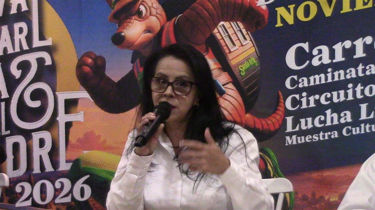 Una de las participantes en la presentación del Festival Familiar Colinas del Padre 2026 habla frente al cartel del evento