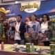 Presentación del Festival Familiar Colinas del Padre 2026 con la botarga del armadillo, playeras del evento y carteles, frente a la manta de Grupo Santa Rita