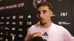 Gonzalo Luján, defensa de Inter Miami, habla con la prensa frente al fondo con el escudo del club.