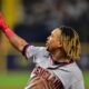 Un jugador de los Guardians de Cleveland con la camiseta gris señala hacia el cielo durante un juego de la ALCS.