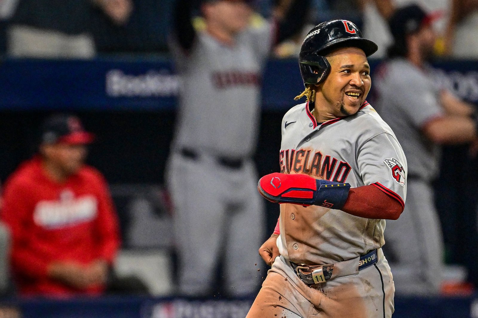 Un jugador de los Guardians de Cleveland con el número 11 sonríe mientras corre tras anotar una carrera en la ALCS.