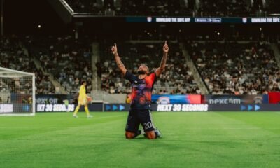 Guilherme, del Houston Dynamo con el número 20, celebra de rodillas con los dos índices hacia el cielo tras un gol en el Snapdragon Stadium, con el portero de San Diego FC al fondo.