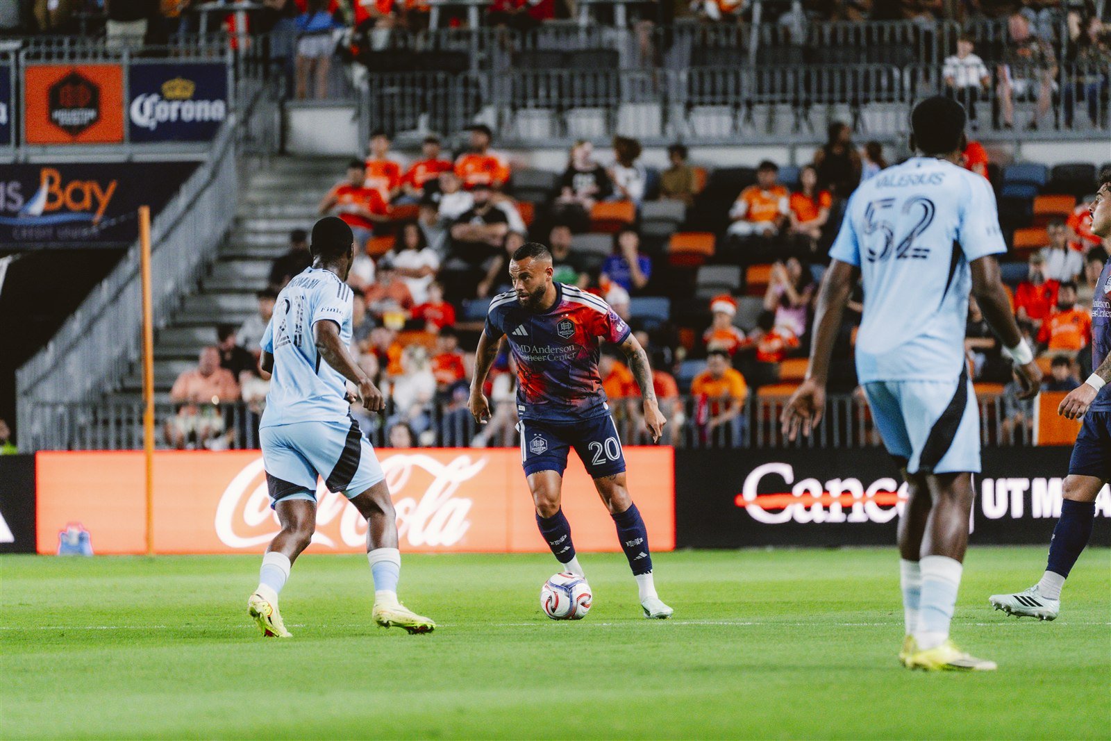 Un jugador del Houston Dynamo conduce el balón ante dos rivales de Minnesota United en el Shell Energy Stadium