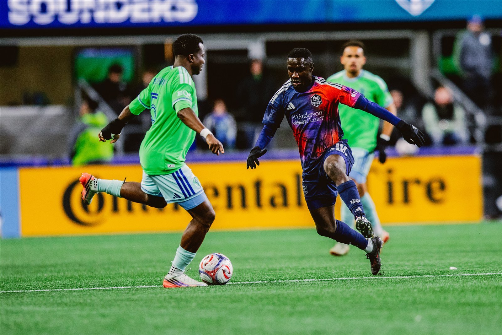 Un jugador del Houston Dynamo y uno de Seattle Sounders disputan el balón en el Lumen Field