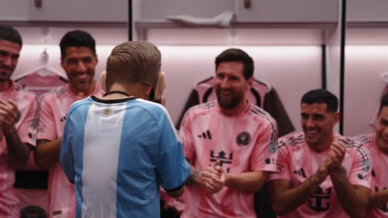 Un niño de la experiencia Make-A-Wish, de espaldas, frente a Lionel Messi, Luis Suárez y otros jugadores del Inter Miami en el vestuario del Nu Stadium