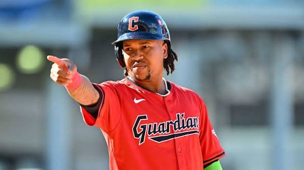 José Ramírez, de los Guardians de Cleveland, señala desde primera base con el uniforme rojo del equipo.