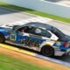 El BMW número 55 de AOA Racing, el equipo de Max Ocaranza, de la categoría GP2 del World Racing League, pasa a gran velocidad por una curva con pianos amarillos.