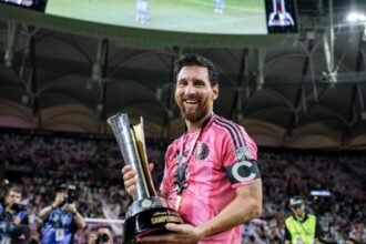 Lionel Messi sonríe con el trofeo de la Campeones Cup en las manos, con la playera rosa de Inter Miami y el brazalete de capitán.