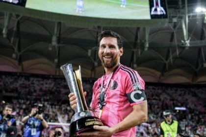 Lionel Messi sonríe con el trofeo de la Campeones Cup en las manos, con la playera rosa de Inter Miami y el brazalete de capitán.