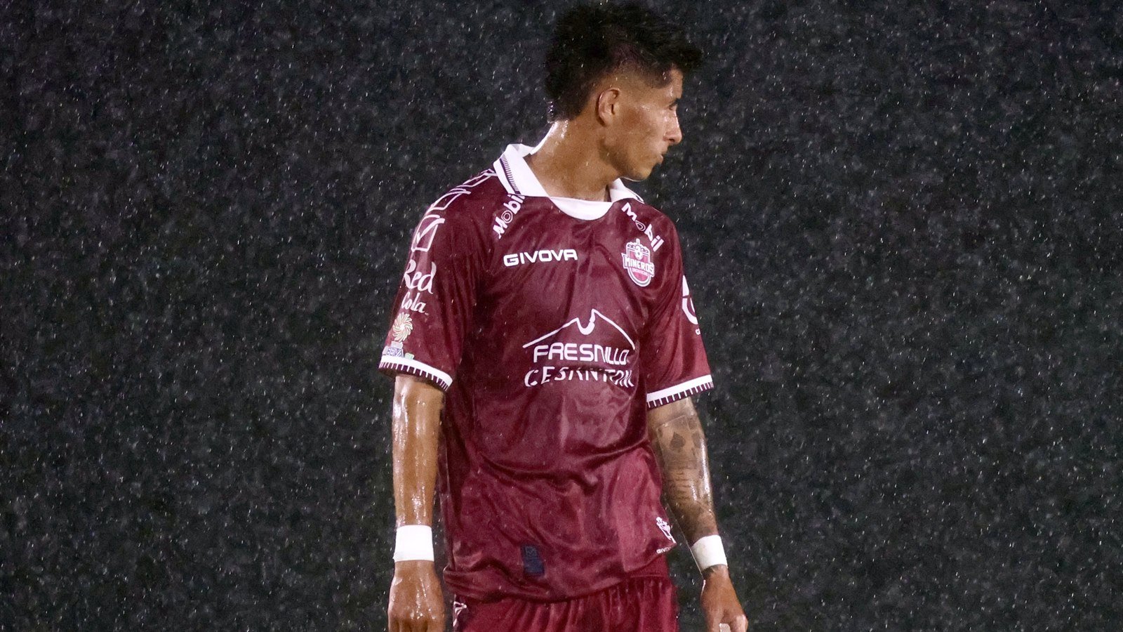 Jugador de Mineros de Zacatecas con el número 11 camina bajo la lluvia durante el partido en Durango.