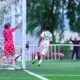Un jugador de Necaxa con el número 324 corre junto a la portería mientras el portero rival levanta los brazos en un partido de la TDP
