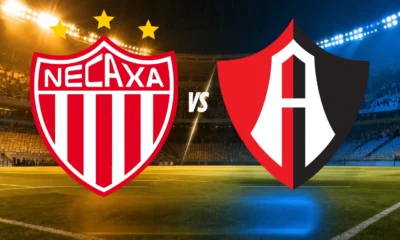 Necaxa vs Atlas: escudos de Necaxa y Atlas con la palabra VS sobre un estadio iluminado, para el partido de la Jornada 12 del Apertura 2026.