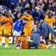 Raúl Jiménez recibe atención médica sentado en el césped durante el partido ante el Everton, con compañeros de los Wolves y el cuerpo médico a su alrededor.