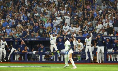 Jugadores y aficionados de los Rays festejan en el Tropicana Field al ganar el campeonato de la Liga Americana