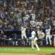 Jugadores y aficionados de los Rays festejan en el Tropicana Field al ganar el campeonato de la Liga Americana
