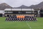Foto oficial de la plantilla de San Diego FC, con jugadores de playera azul marino, porteros de naranja y las montañas al fondo, en el centro de entrenamiento.
