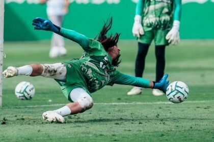 Un portero de Santos Laguna se estira para atajar el balón durante un entrenamiento, con otro portero de pie al fondo.