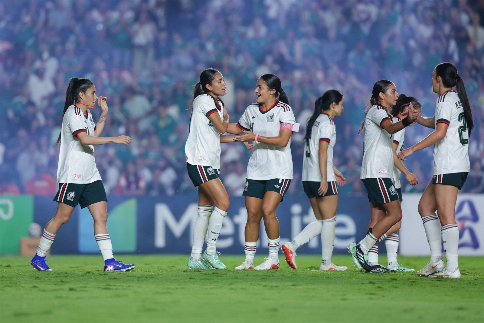 Jugadoras de la Selección Mexicana Femenil, con uniforme blanco, se felicitan y celebran durante el amistoso ante Jamaica.