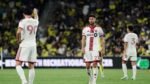 Mediocampista de Toronto FC con el número 21 y el brazalete de capitán, en un partido de la MLS, con dos compañeros al fondo.